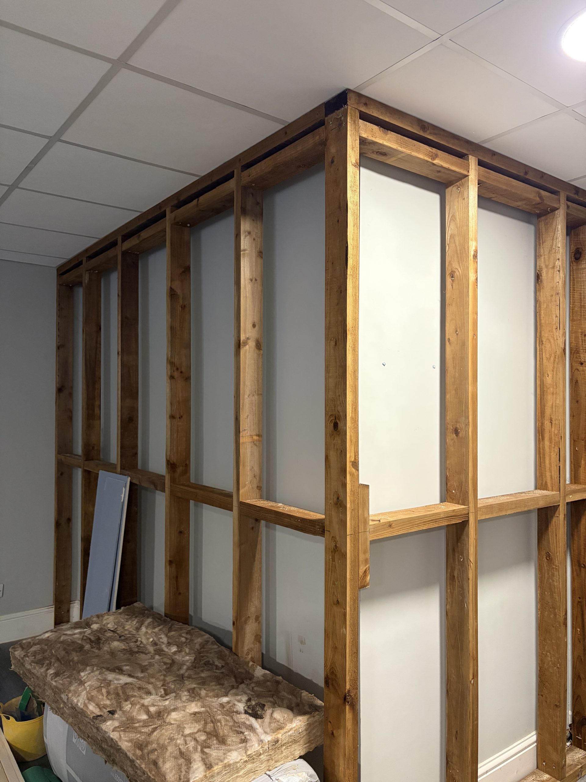 A wooden frame installed into an internal wall, ready for insulation to be put in.